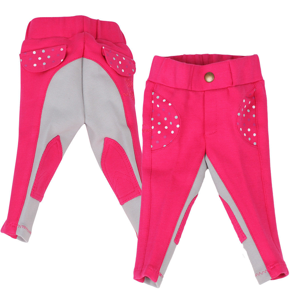 Bright pink children's riding breeches with grey seat and leg panels, featuring polka dot detailing on the pockets - front and rear views shown.